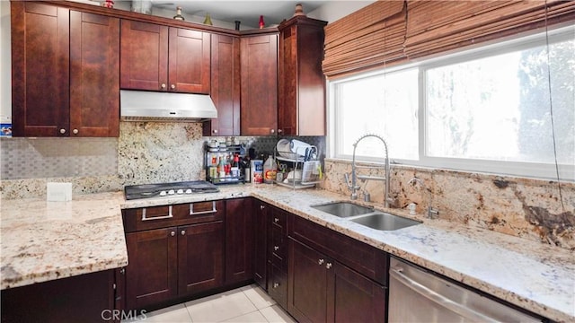 kitchen with light stone countertops, sink, stainless steel appliances, decorative backsplash, and light tile patterned flooring