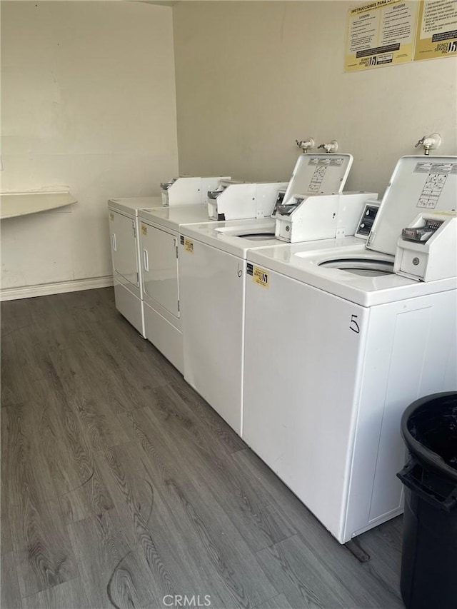 clothes washing area with dark hardwood / wood-style floors and independent washer and dryer