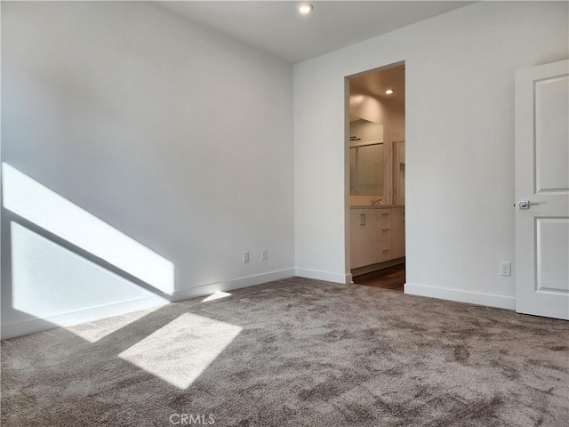 unfurnished room with dark colored carpet