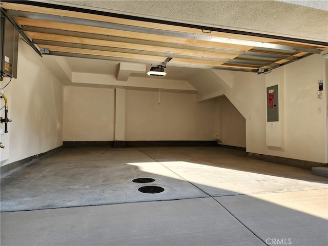 garage with electric panel and a garage door opener