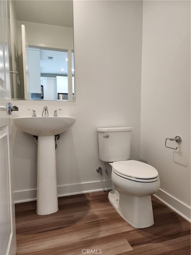 bathroom featuring wood-type flooring and toilet