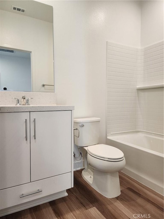 full bathroom with hardwood / wood-style floors, vanity, toilet, and shower / tub combination