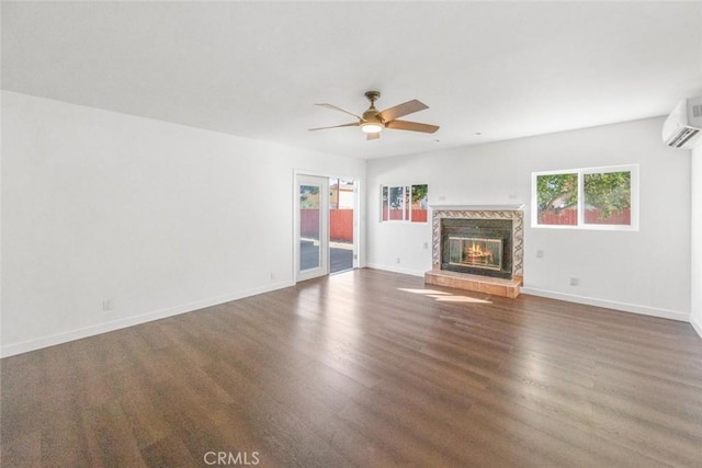 unfurnished living room featuring ceiling fan, dark hardwood / wood-style flooring, a fireplace, and a wall mounted AC