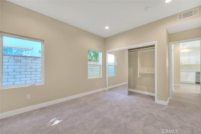 unfurnished bedroom featuring a closet and light colored carpet