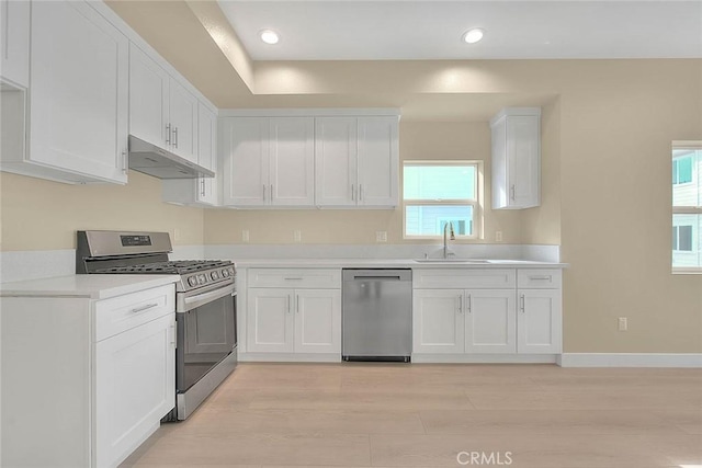 kitchen featuring appliances with stainless steel finishes, white cabinetry, and sink