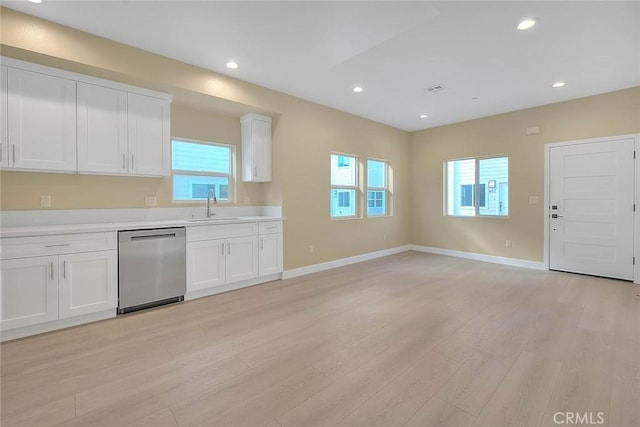 kitchen with dishwasher, light wood-type flooring, white cabinetry, and sink