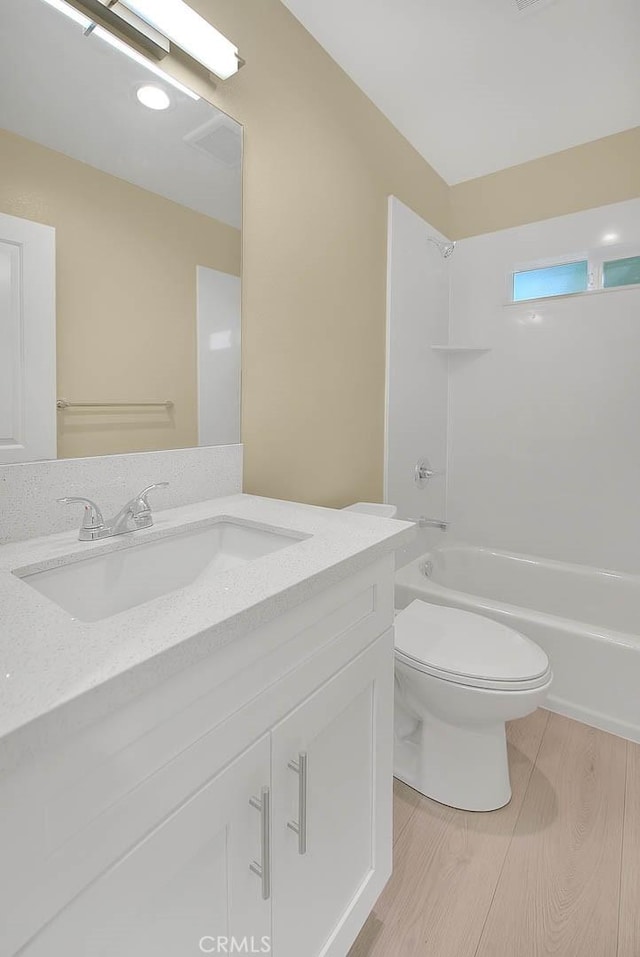 full bathroom featuring vanity, bathing tub / shower combination, hardwood / wood-style flooring, and toilet