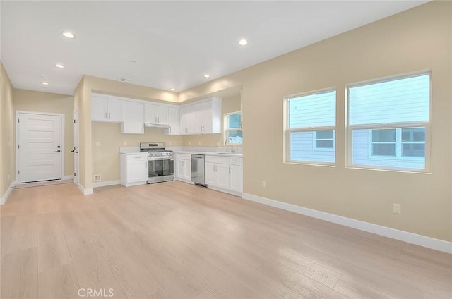 kitchen with white cabinets, stainless steel appliances, light hardwood / wood-style flooring, and sink