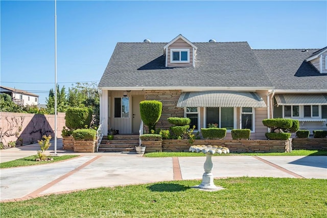 cape cod home featuring a front yard