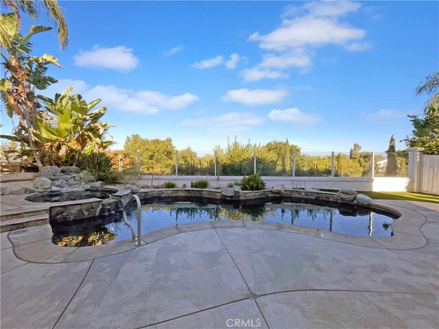 view of swimming pool with a hot tub