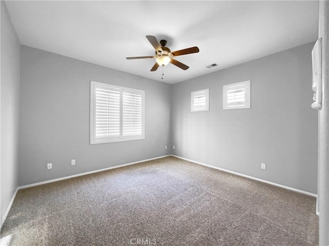 carpeted spare room featuring ceiling fan