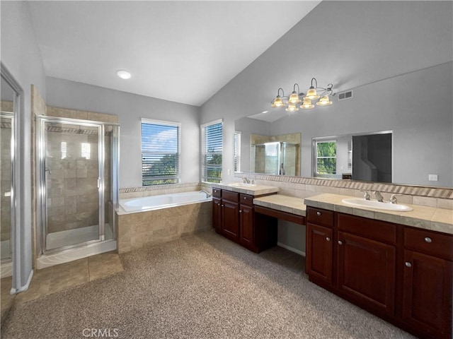 bathroom featuring vanity, independent shower and bath, and lofted ceiling