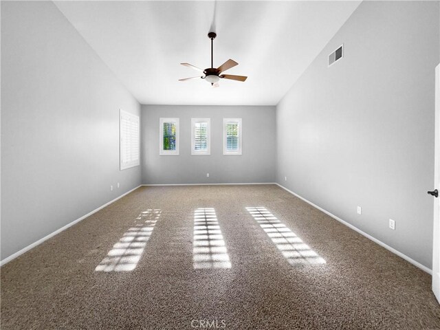 empty room featuring carpet, vaulted ceiling, and ceiling fan