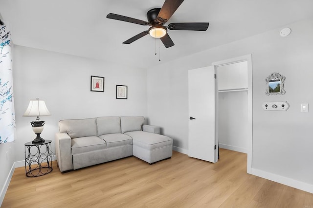 living room with ceiling fan and light hardwood / wood-style flooring