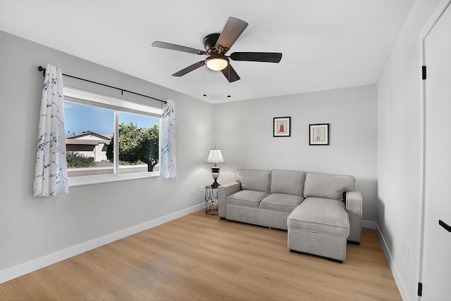 living room featuring light hardwood / wood-style flooring and ceiling fan