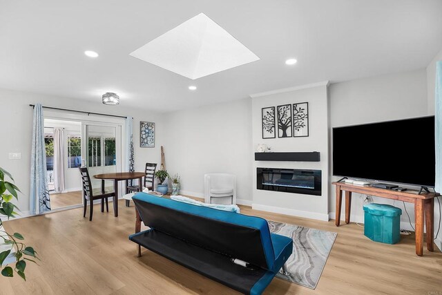 living room featuring a skylight and light hardwood / wood-style flooring