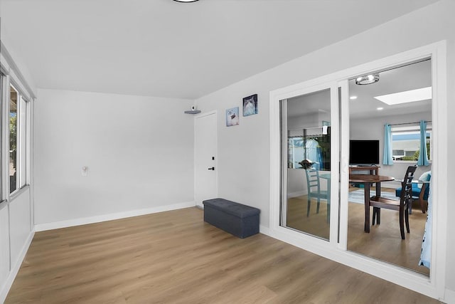 unfurnished room with a skylight and hardwood / wood-style flooring