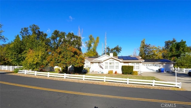 view of front of property with a garage and solar panels