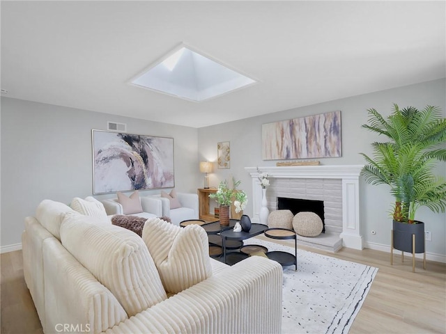 living room featuring a skylight and light hardwood / wood-style floors