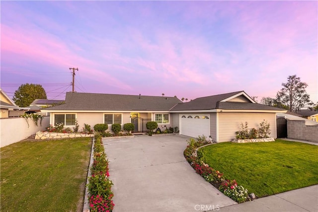 ranch-style home featuring a lawn and a garage