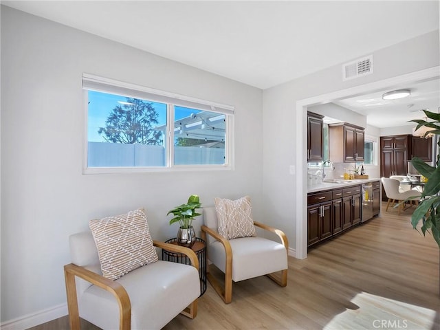 living area featuring light hardwood / wood-style floors and sink