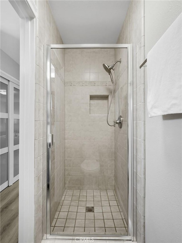 bathroom featuring wood-type flooring and a shower with door