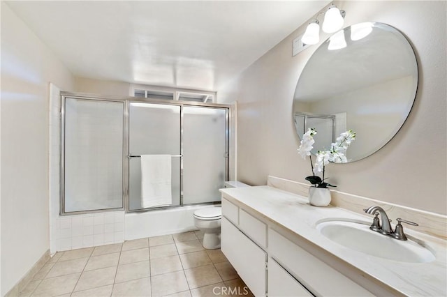 full bathroom featuring shower / bath combination with glass door, tile patterned floors, vanity, and toilet