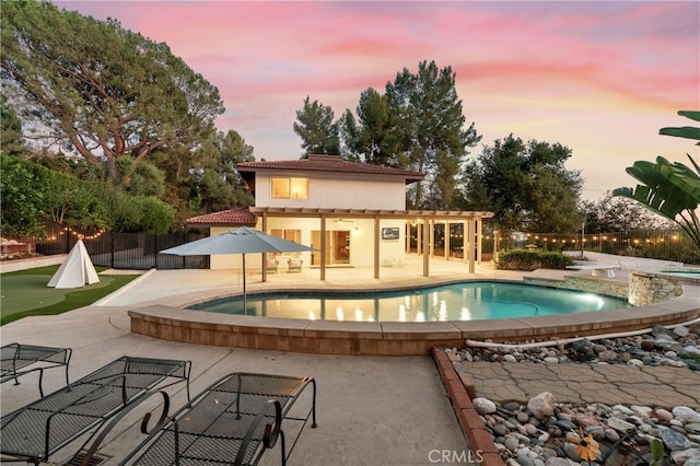 pool at dusk with a patio