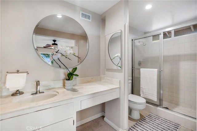 bathroom featuring vanity, a shower with door, ceiling fan, tile patterned flooring, and toilet