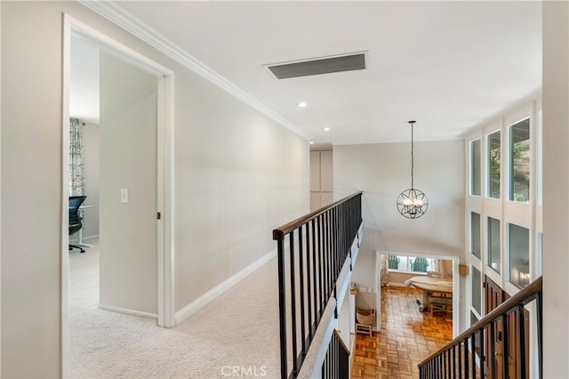 hall with light parquet floors, an inviting chandelier, and ornamental molding