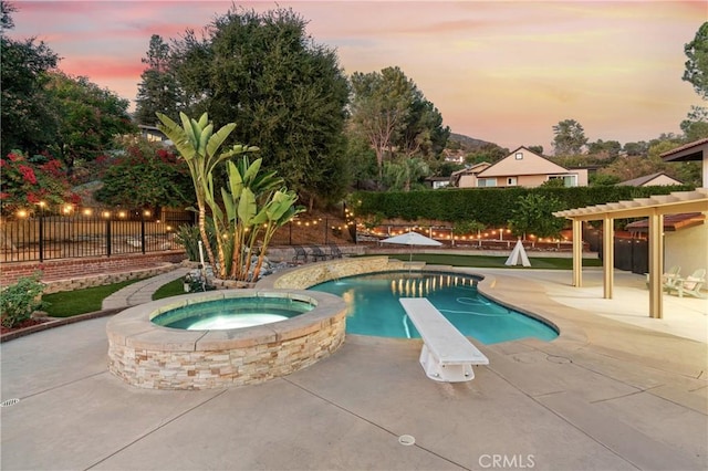 pool at dusk with an in ground hot tub, a pergola, a diving board, and a patio area