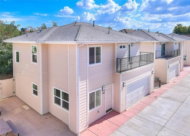 rear view of house with a balcony and a garage