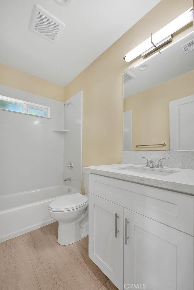 full bathroom with vanity, toilet, wood-type flooring, and shower / tub combination