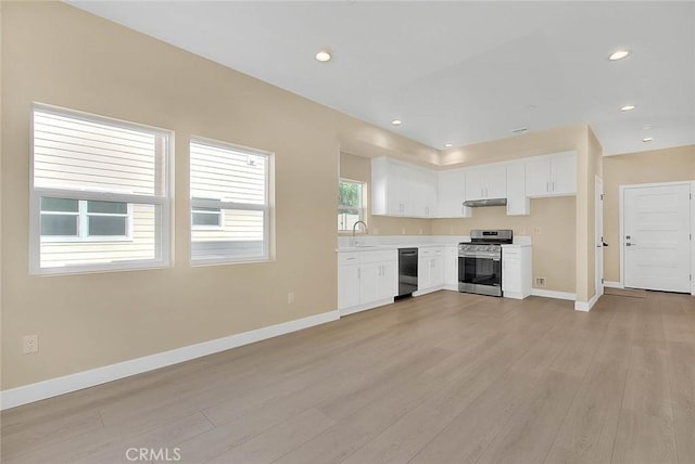 kitchen featuring stainless steel range oven, white cabinetry, black dishwasher, and light hardwood / wood-style flooring