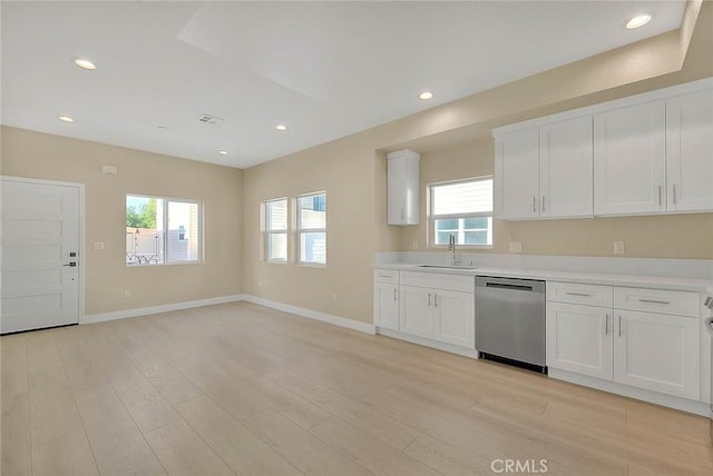 kitchen featuring dishwasher, white cabinets, light hardwood / wood-style flooring, and a wealth of natural light