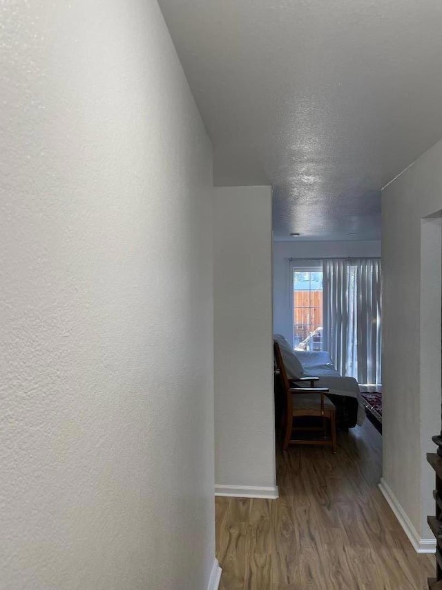 hallway featuring hardwood / wood-style flooring and a textured ceiling