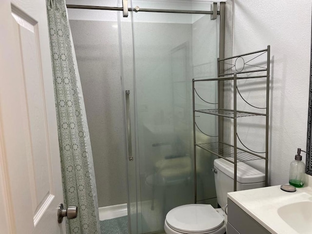 bathroom with vanity, an enclosed shower, and toilet