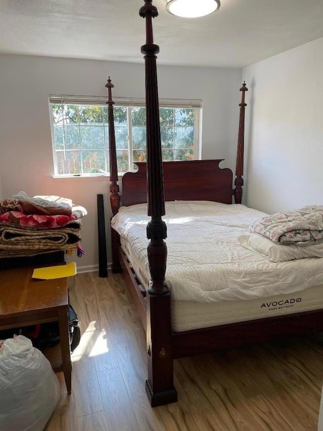 bedroom with hardwood / wood-style floors and multiple windows