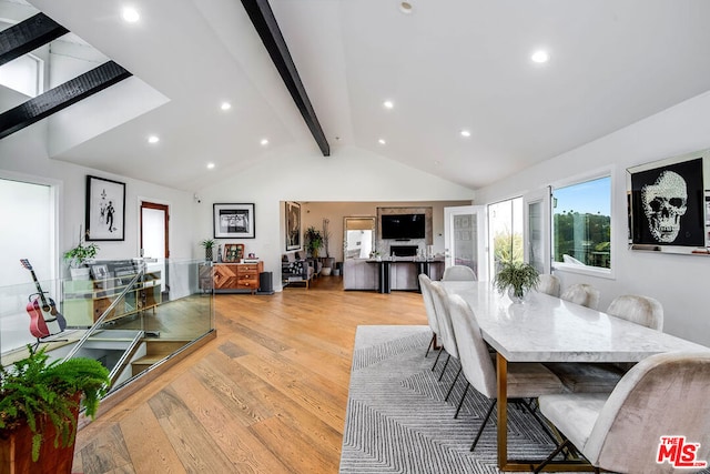 dining area featuring beam ceiling, high vaulted ceiling, and light wood-type flooring