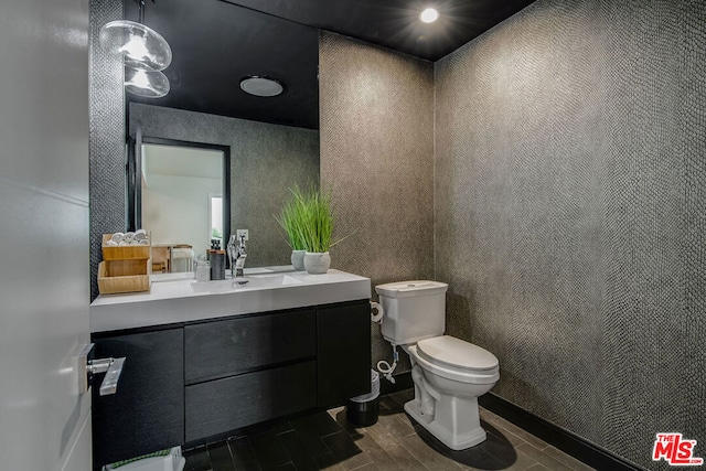 bathroom with vanity, toilet, and wood-type flooring