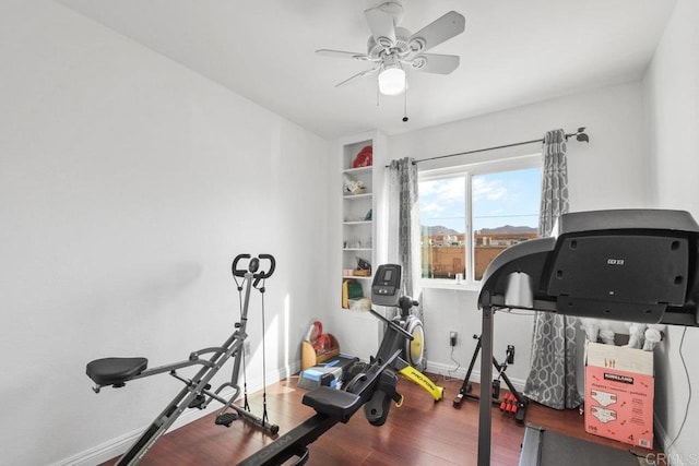 exercise room with ceiling fan and wood-type flooring