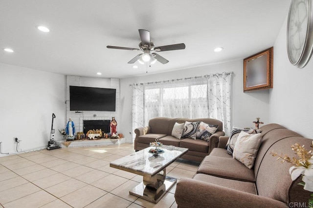 tiled living room with a fireplace and ceiling fan