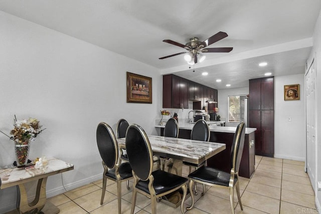 tiled dining room with ceiling fan and sink