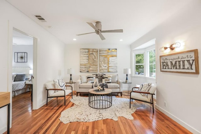 living room featuring hardwood / wood-style floors and ceiling fan