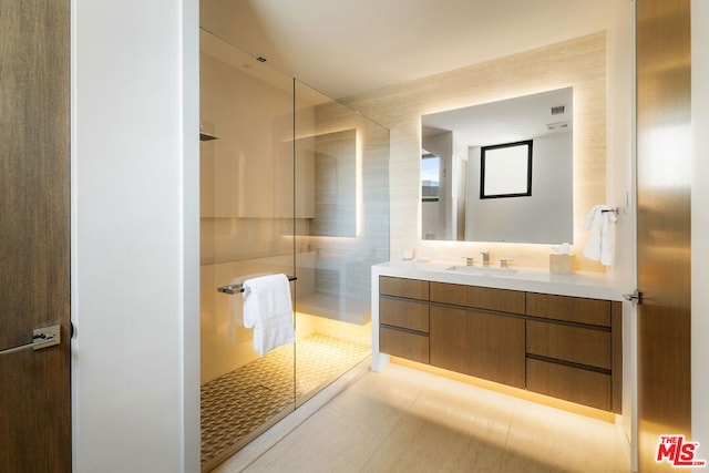 bathroom featuring a shower, vanity, and tile patterned flooring