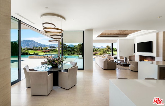 dining room featuring a mountain view, expansive windows, and an inviting chandelier