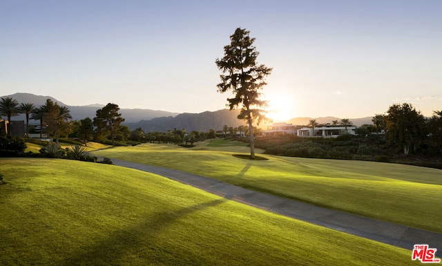 surrounding community with a mountain view and a yard