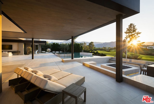 view of patio with a mountain view and a fire pit