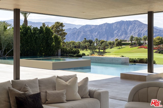 view of swimming pool with a mountain view, a patio area, and a jacuzzi