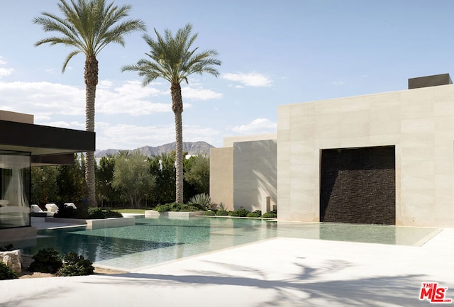 view of swimming pool with a mountain view and a patio